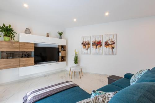 a living room with a blue couch and a tv at H2 -Modern and Spacious 3 Bedroom Apartment in San Ġwann