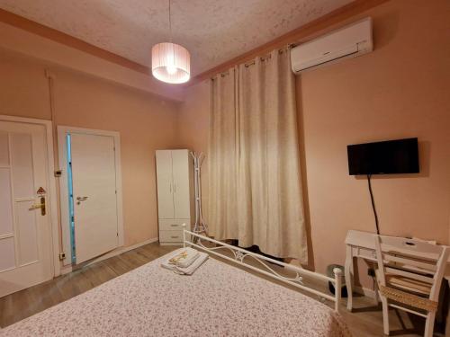 um quarto com uma cama, uma televisão e uma janela em B&B Elisa em Crotone