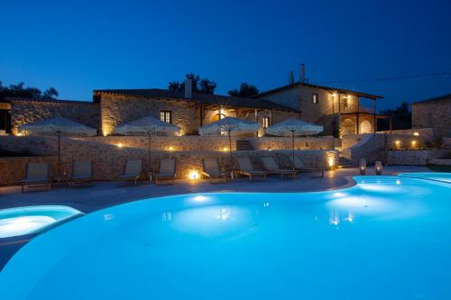 a swimming pool in front of a villa at night at Luxury Villa Happynest in Spasméni Vrísi