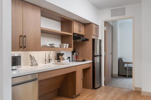 a kitchen with wooden cabinets and a sink at Element Denver Downtown East in Denver