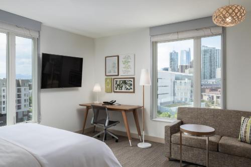 a hotel room with a bed and a desk and window at Element Denver Downtown East in Denver