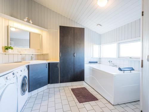 ein großes Bad mit einer Waschmaschine und einem Waschbecken in der Unterkunft 6 person holiday home on a holiday park in Hvide Sande in Bjerregård