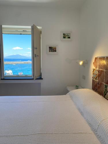 a bedroom with a bed with a view of the ocean at La Baia di Napoli in Capri