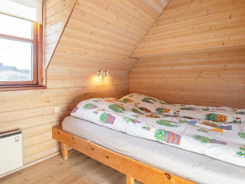 ブラーバンドにあるTwo-Bedroom Holiday home in Blåvand 3の窓付きの木造キャビンのベッド1台分です。