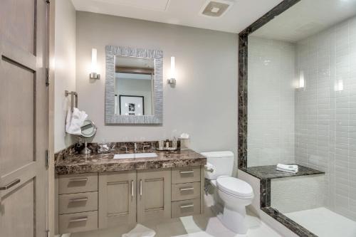 a bathroom with a sink and a toilet and a mirror at Stein Eriksen Residences in Park City