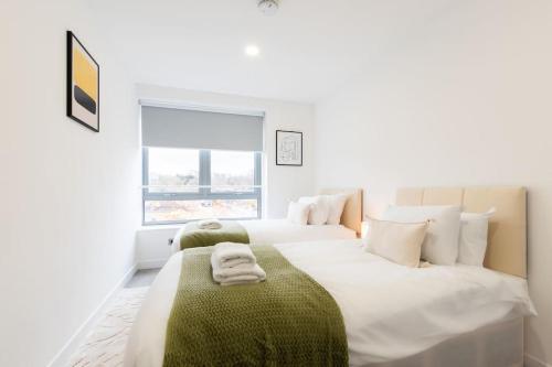 2 Betten in einem Zimmer mit weißen Wänden in der Unterkunft Coral - 2 Bedroom Flat in Bracknell