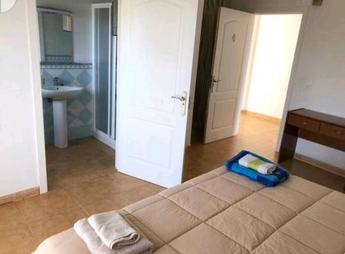 Zimmer mit einem Bett und einem Bad mit einem Waschbecken in der Unterkunft Cortijo la Umbria in Villanueva de Algaidas