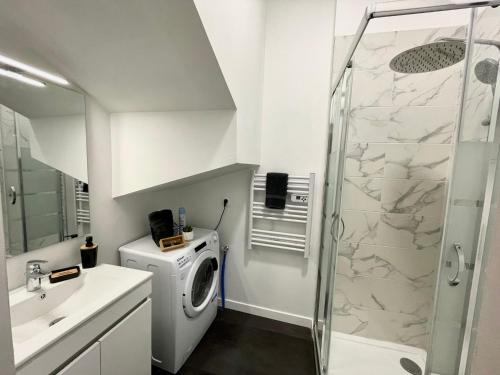 a bathroom with a washing machine and a shower at LE VOLTA - Appartement - Centre ville Calais in Calais