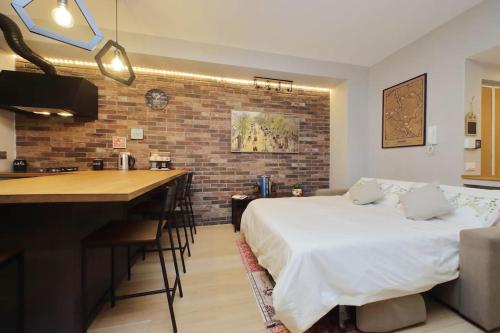 1 dormitorio con 1 cama y cocina con barra. en Casina degli Eroi, en Roma