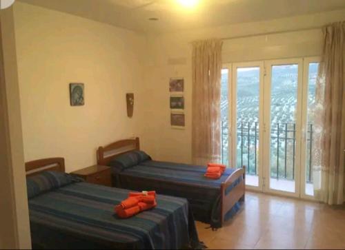 1 Schlafzimmer mit 2 Betten und einem Balkon in der Unterkunft Cortijo la Umbria in Villanueva de Algaidas
