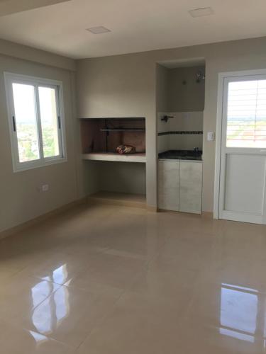 Habitación vacía con suelo blanco y ventanas en Depto en Tucumán en San Miguel de Tucumán