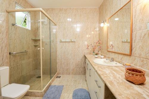 uma casa de banho com um chuveiro, um WC e um lavatório. em Casa Amarela em Angra dos Reis