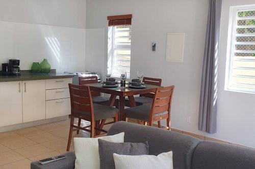 a living room with a table and chairs and a kitchen at Gamay Souterrain Apartment, near beach in Curaçao in Jan Thiel