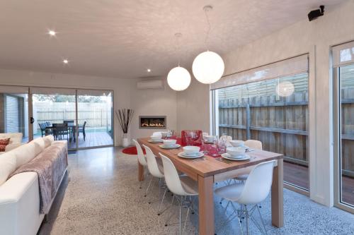 a dining room with a table and chairs and a couch at Amaroo in Queenscliff