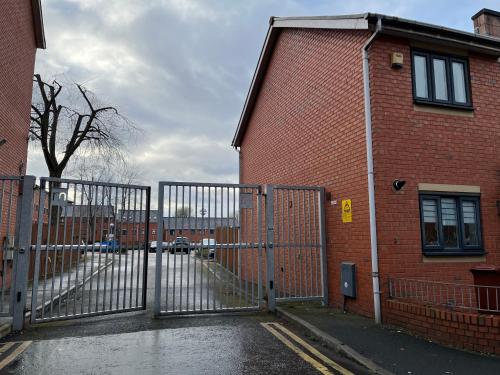 a metal gate in front of a brick building at Entire house with parking in Manchester