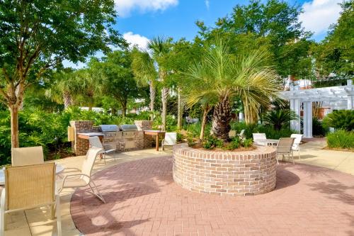 a patio with a palm tree in a brick planter at Baytowne Wharf - Observation Point North #460 in Destin