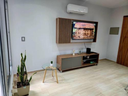 sala de estar con TV de pantalla plana en la pared en Altos de Mendoza en Mendoza