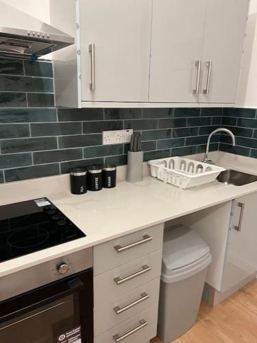 a kitchen with white cabinets and a counter with a sink at 004- Brand new 1 bedroom apartment F1 in Ealing