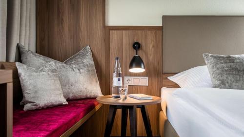 a hotel room with a bed and a bottle on a table at Dorint Parkhotel Siegen in Siegen