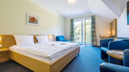 a hotel room with a bed and a balcony at Dorint Parkhotel Siegen in Siegen