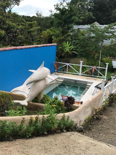 a shark statue next to a swimming pool at FLOR DE PARAISO BUNGALOWS in Montezuma