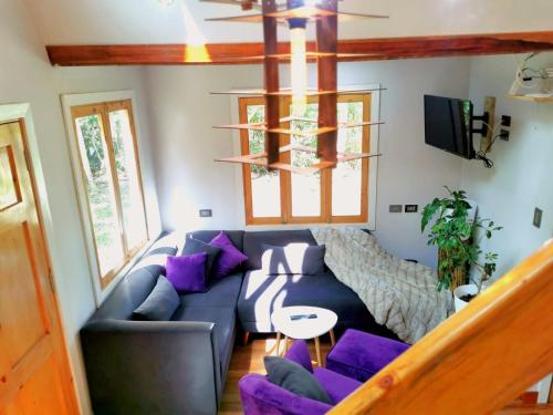 salon z niebieską kanapą i fioletowymi poduszkami w obiekcie Oxablues Home Lodge w mieście Oxapampa