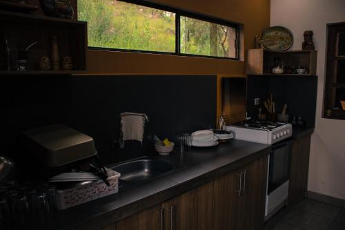 a kitchen with a sink and a stove and a window at Casa de Campo La Montaña in Tarija