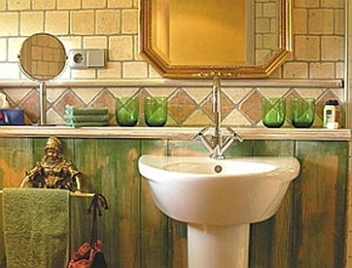 a bathroom with a sink and a mirror and green vases at Haus Silbermond in Rust