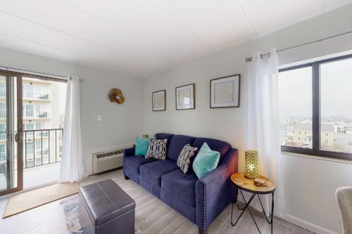 a living room with a blue couch and a window at Decatur House 501 in Ocean City