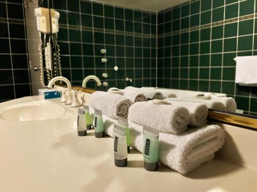 a bathroom with towels and a sink and a mirror at Stay at Alice Springs Hotel in Alice Springs
