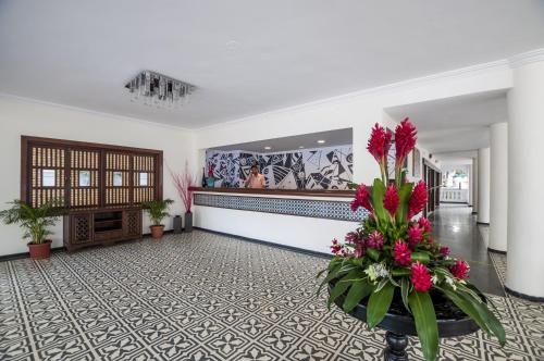 a lobby with flowers in a vase on the floor at Radisson Goa Candolim in Candolim