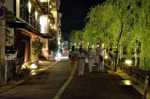 a group of people walking down a street at night at Kinosaki Yamamotoya in Toyooka