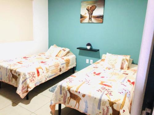 a bedroom with two beds and a picture on the wall at Tu refugio en CDMX cerca del Foro Sol y del AICM in Mexico City