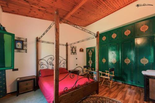 a bedroom with a canopy bed and green walls at Casa Plasa Grande CHEFCHAOUEN in Chefchaouene