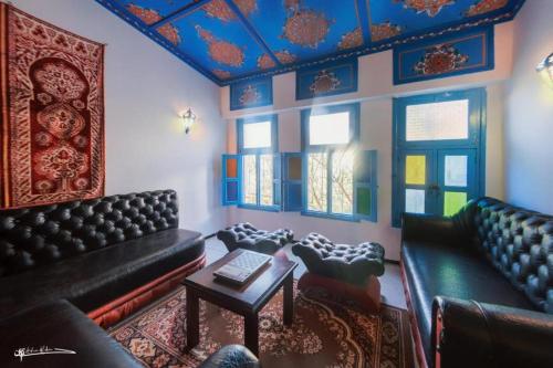 a living room with couches and a table and windows at Casa Plasa Grande CHEFCHAOUEN in Chefchaouene