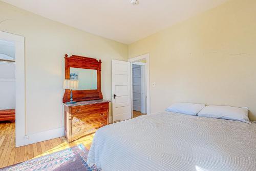 a bedroom with a bed and a dresser and a mirror at A Villager's Dream in North Conway