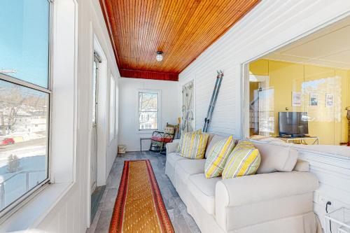 a living room with a white couch and a window at A Villager's Dream in North Conway