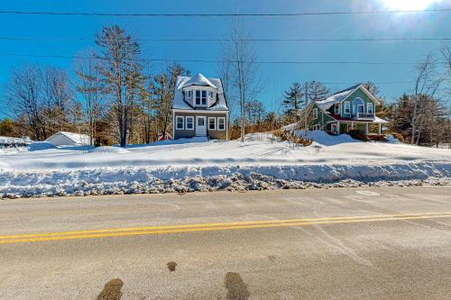 two houses on the side of a road with snow at A Villager's Dream in North Conway