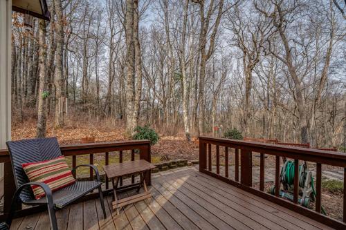 a wooden deck with a bench and a chair on it at The Bird House in Dillard