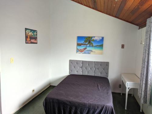 um quarto com uma cama e uma mesa num quarto em Casa em condominio no Pero - Cabo Frio em Cabo Frio