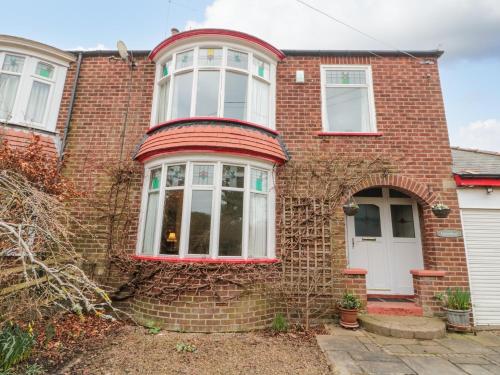 a red brick house with a white door at Clover Leaf in Guisborough