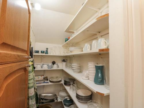 a cupboard filled with lots of white dishes at Clover Leaf in Guisborough