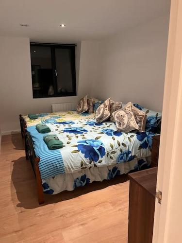 a bedroom with a bed with a blue and white comforter at 021- Two bedrooms in Ealing 2 in Ealing