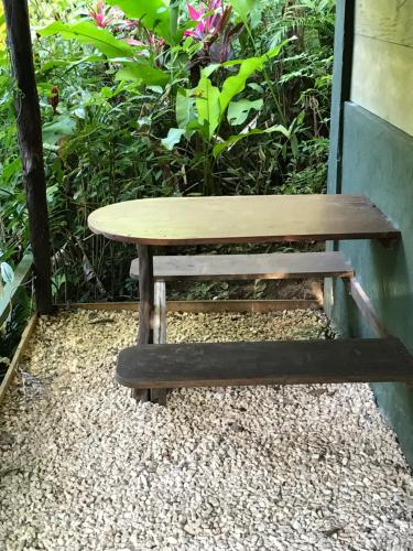 a wooden bench sitting next to a table at FLOR DE PARAISO BUNGALOWS in Montezuma