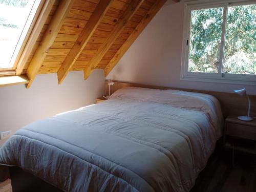 1 cama en un dormitorio con ventana grande en Cielo de sierra en Sierra de los Padres