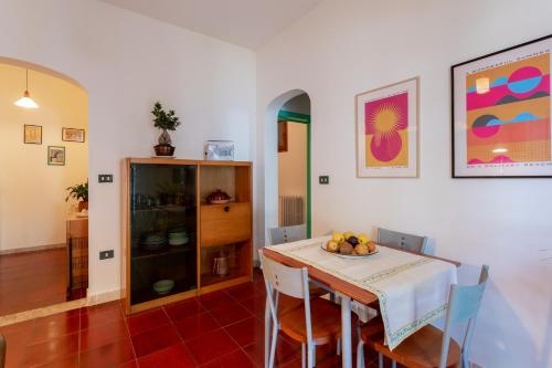 Artemisia Homes - Villa Cristina al Mare في مارينا بورتو: غرفة طعام مع طاولة مع وعاء من الفواكه عليها