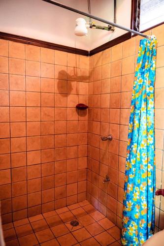 a shower with a blue shower curtain in a bathroom at FLOR DE PARAISO BUNGALOWS in Montezuma
