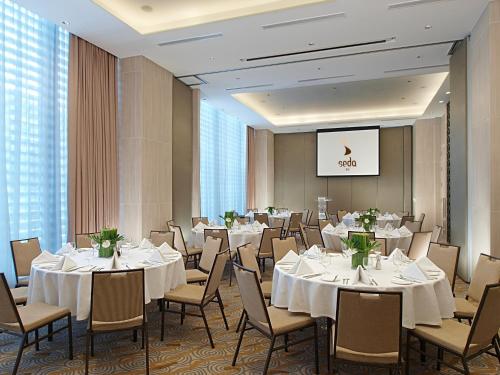 a banquet room with white tables and chairs at Seda Bonifacio Global City in Manila