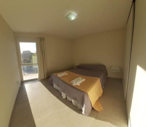 a small bedroom with two beds and a window at TEMPORARIOS ROCA in General Roca