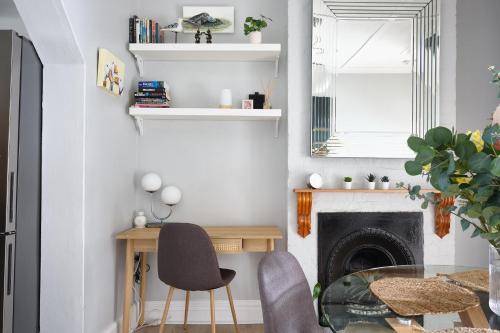a living room with a table and chairs and a fireplace at Redfern Classic Terrace - Parking and Balcony in Sydney